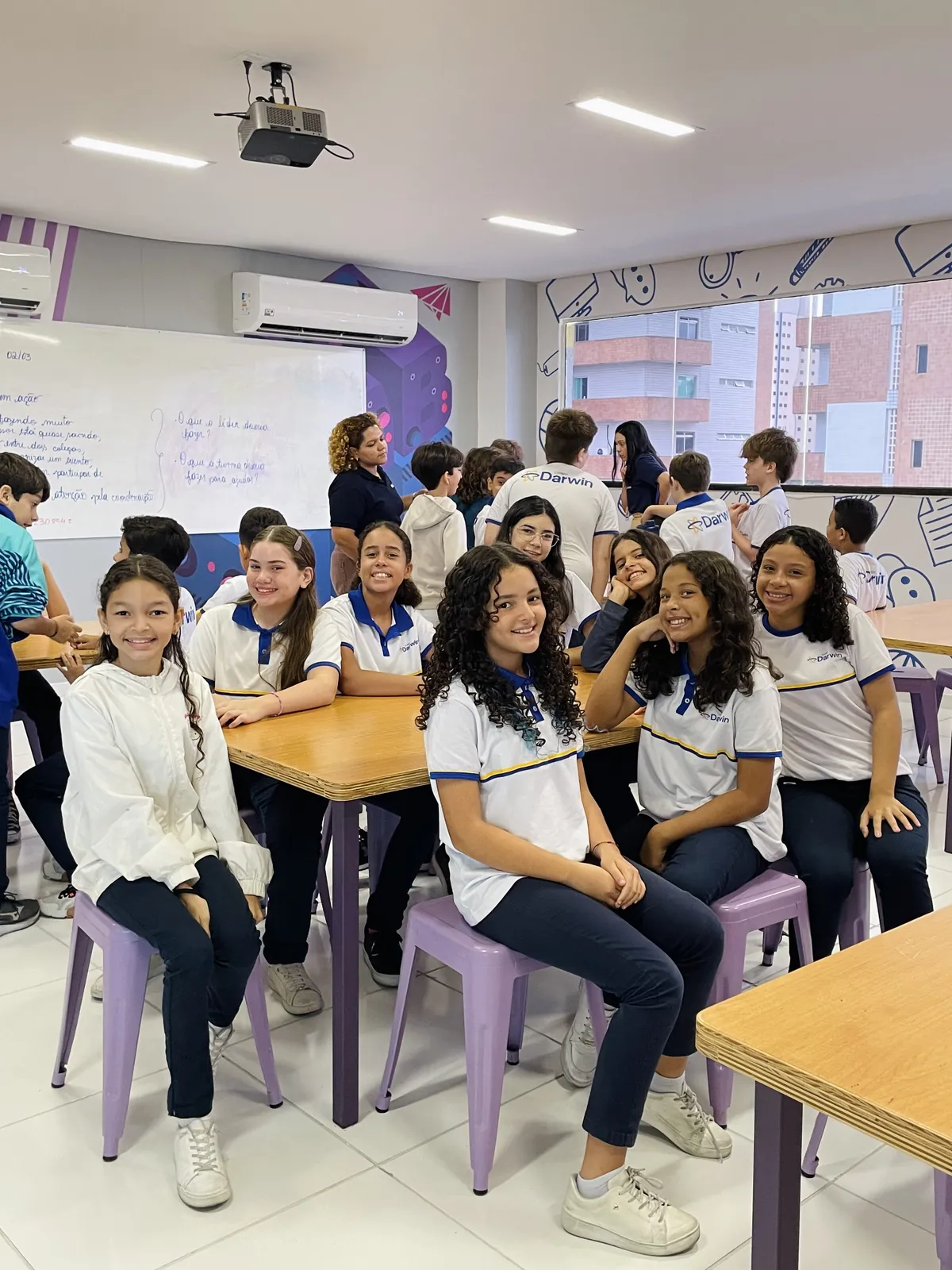 Turma dos Anos Finais reunida ao redor de mesa em atividade colaborativa.