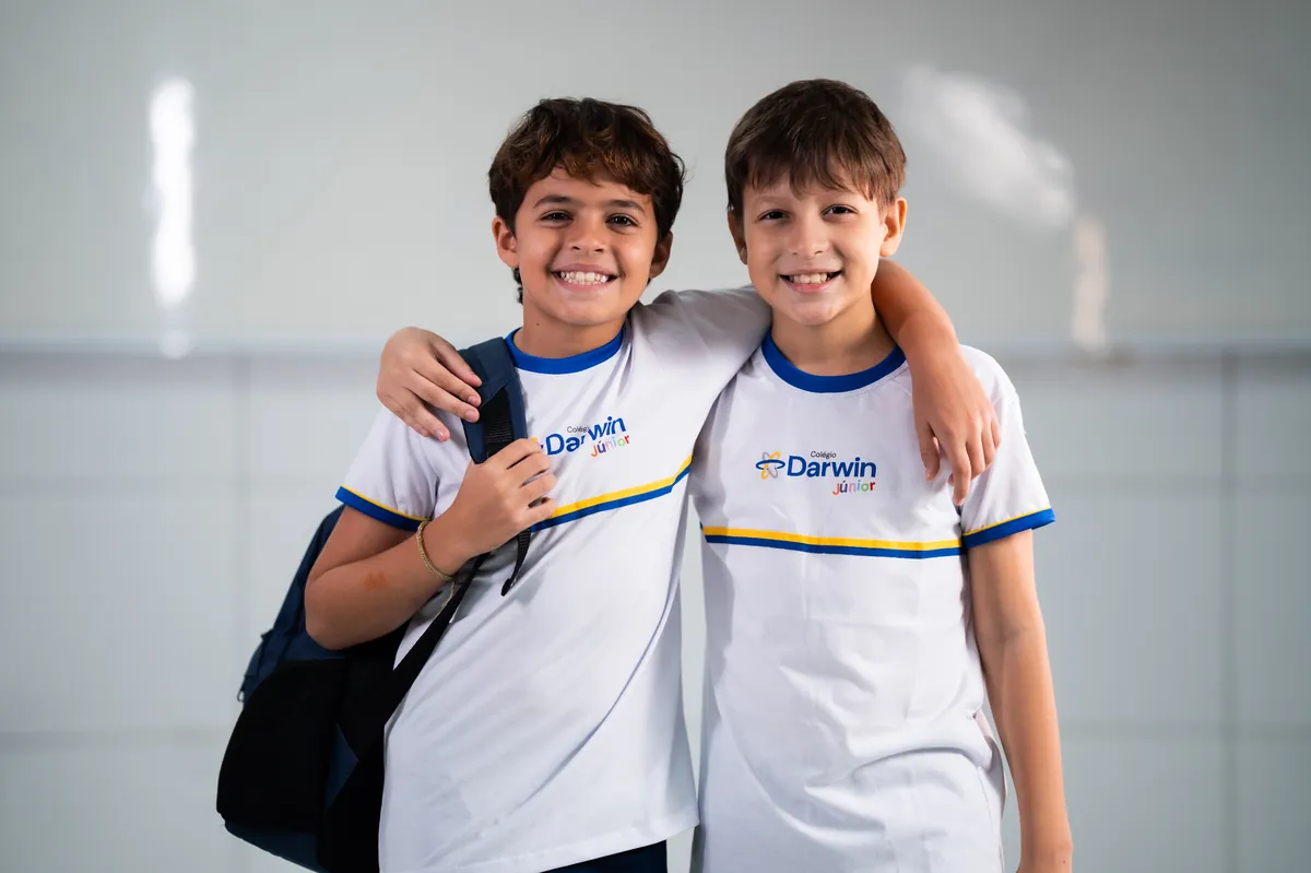 Dois meninos dos Anos Iniciais abraçados com uniforme Darwin.