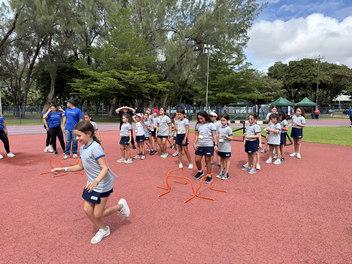 Alunos dos Anos Iniciais em atividade esportiva ao ar livre em pista atlética.