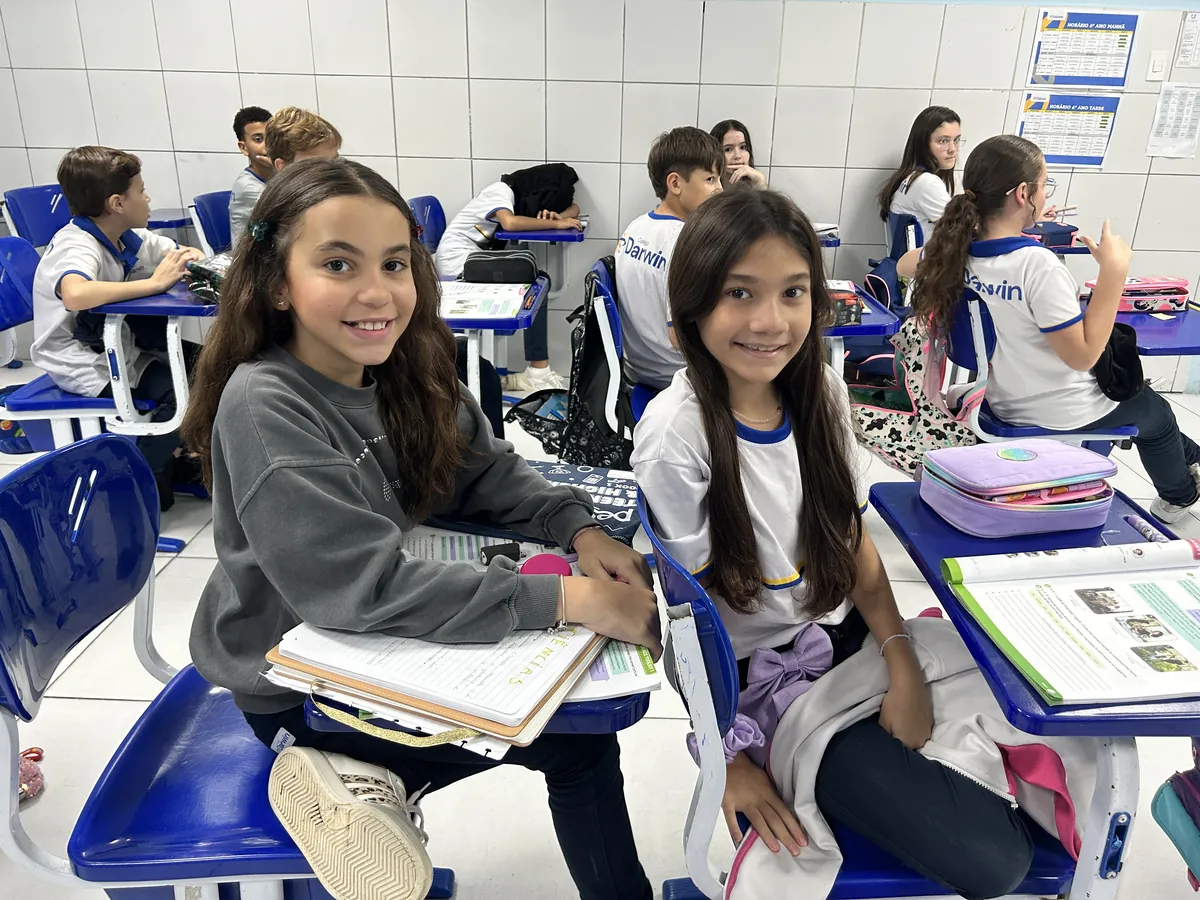 Duas alunas sorrindo em sala de aula durante atividade do setor de Psicologia.