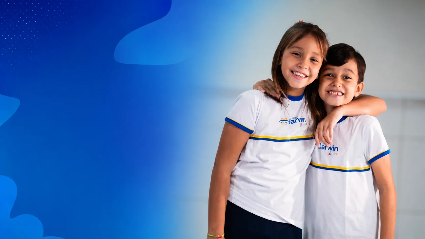 Dois alunos do Colégio Darwin abraçados e sorrindo