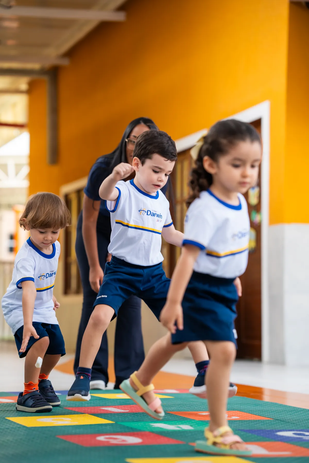 Crianças da Educação Infantil brincando de amarelinha no Darwin