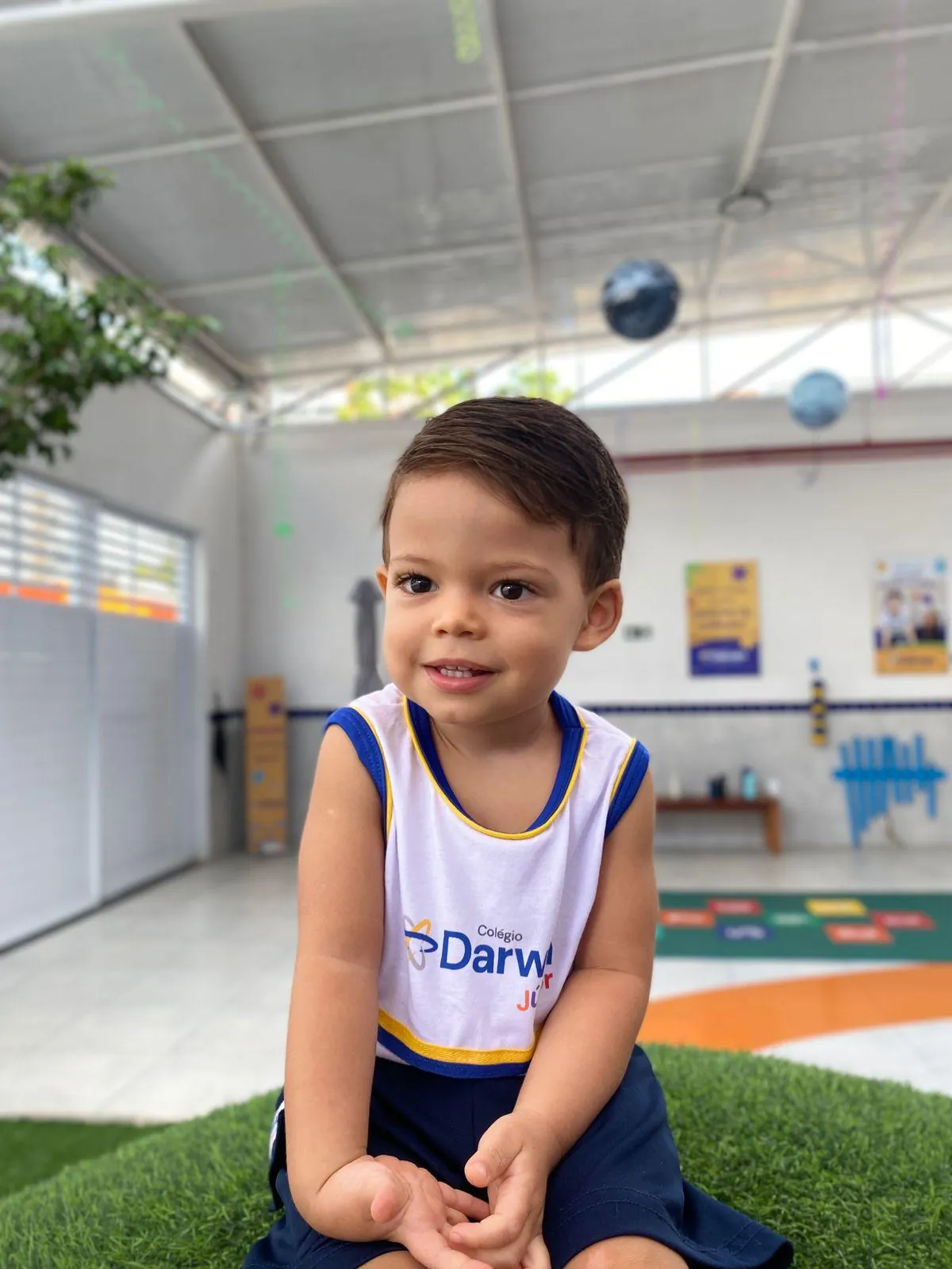 Menino sentado em ambiente lúdico do Darwin Júnior.