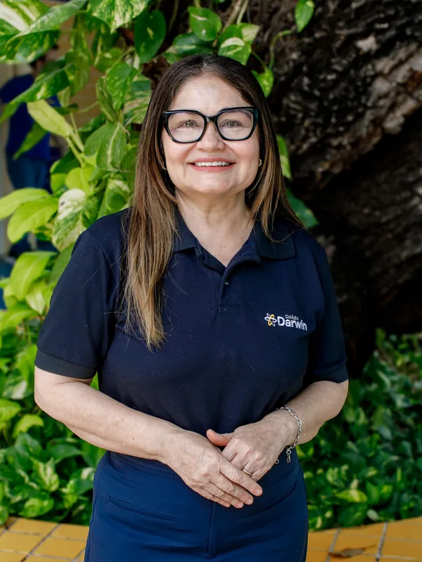 Regina Lobão, diretora pedagógica do Colégio Darwin, de óculos e uniforme, no pátio externo
