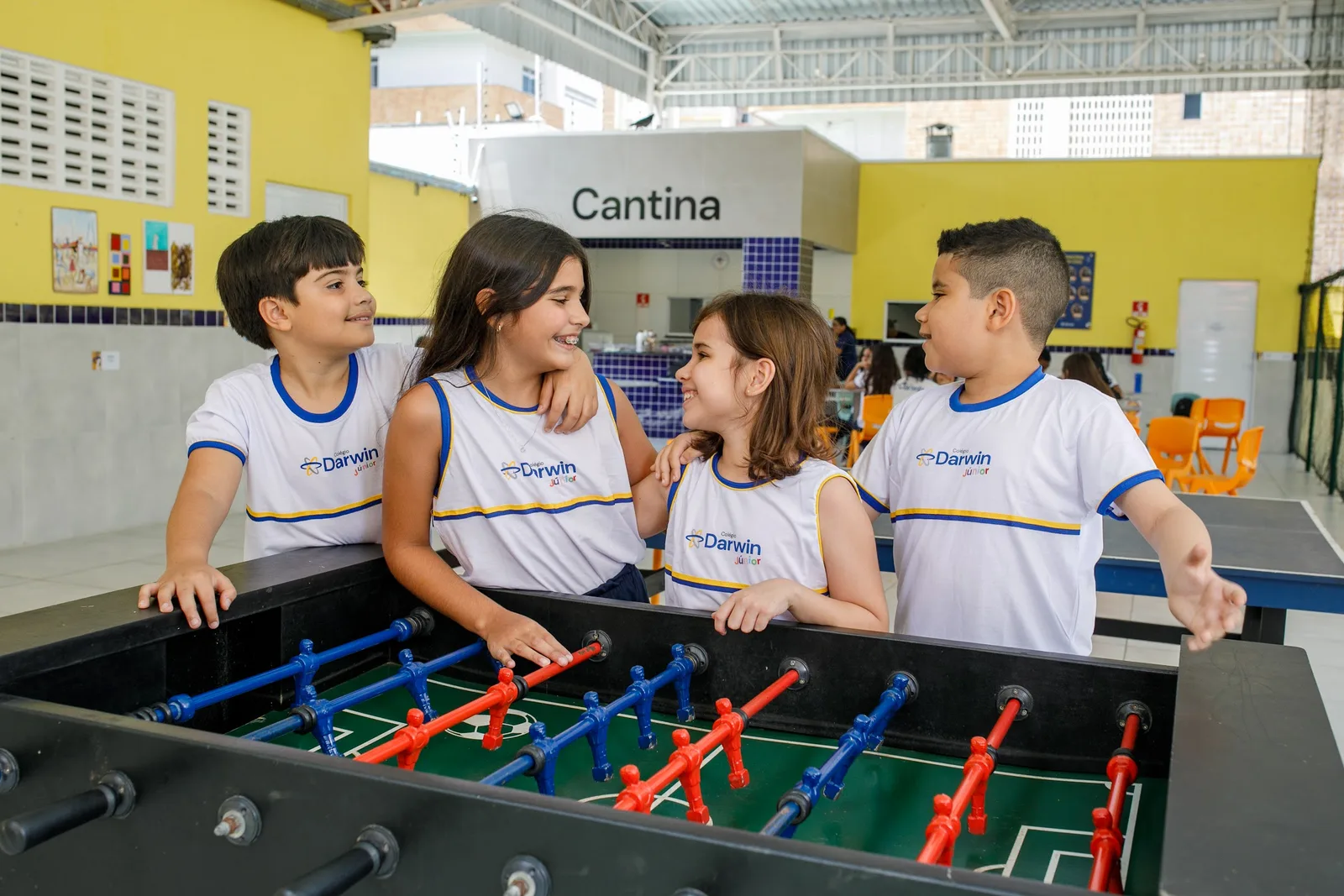 Alunos jogando pebolim no pátio de convivência da Sede Dionísio Torres, ao lado da cantina