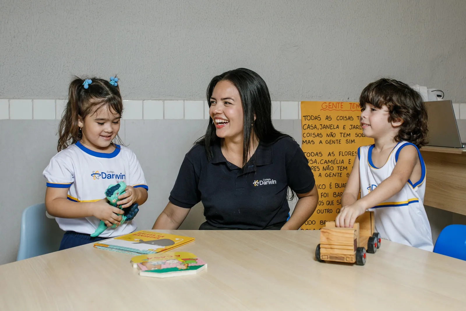 Professora do Darwin e dois alunos em volta de um jogo de mesa na sede Sul.